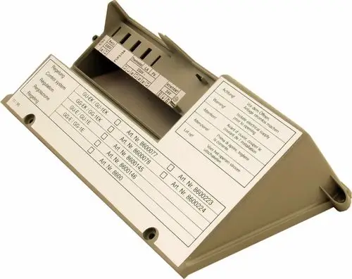 Gehäuse für Steuerungsregelung, beige, mit Anschlussmöglichkeiten und Artikelliste, hergestellt von Wolf. Warnhinweise und Installationshinweise sind auf dem Deckel vermerkt.